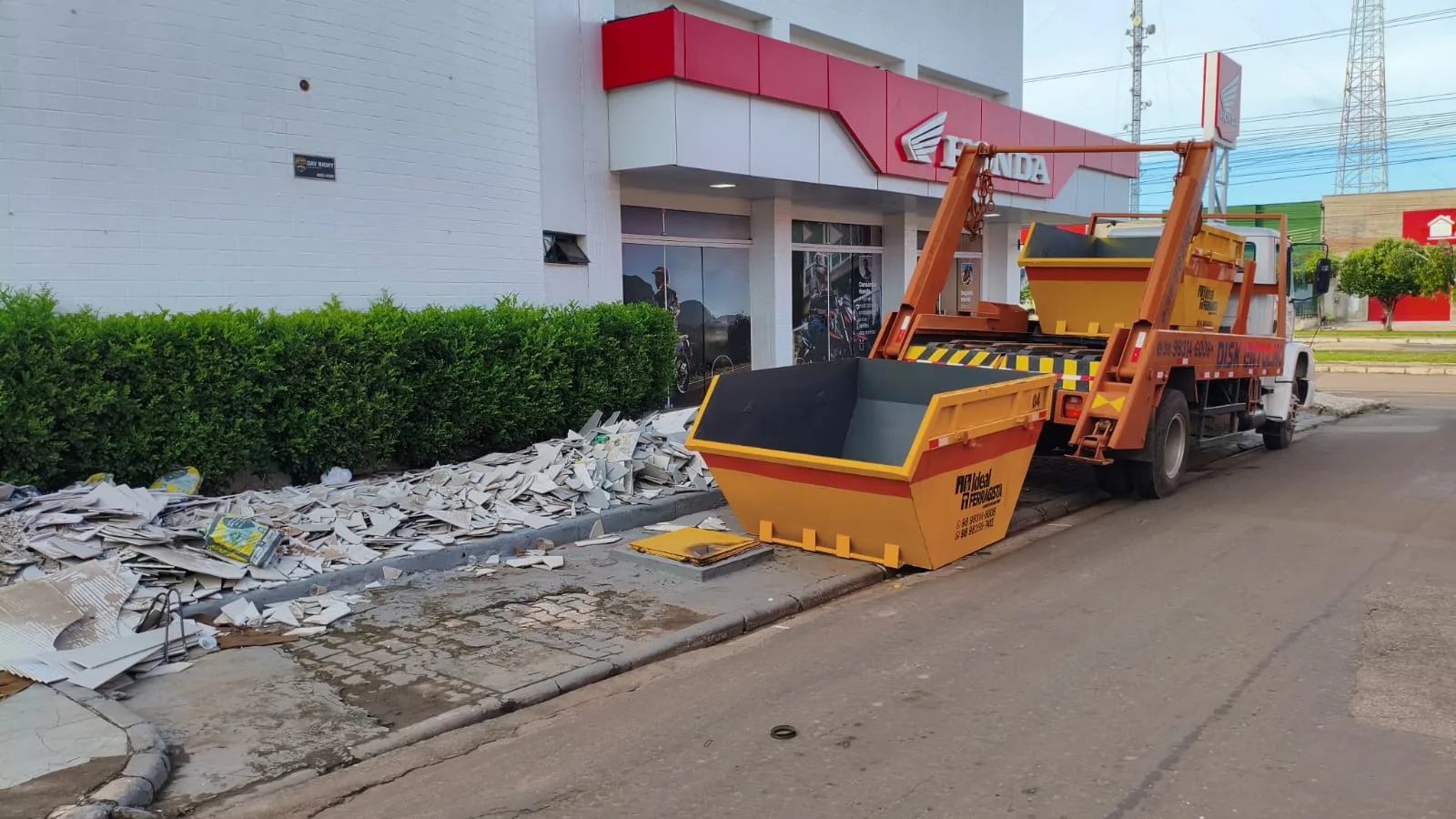 Caminhão descarregando caçamba de entulho em um terreno em Santa Inês-MA